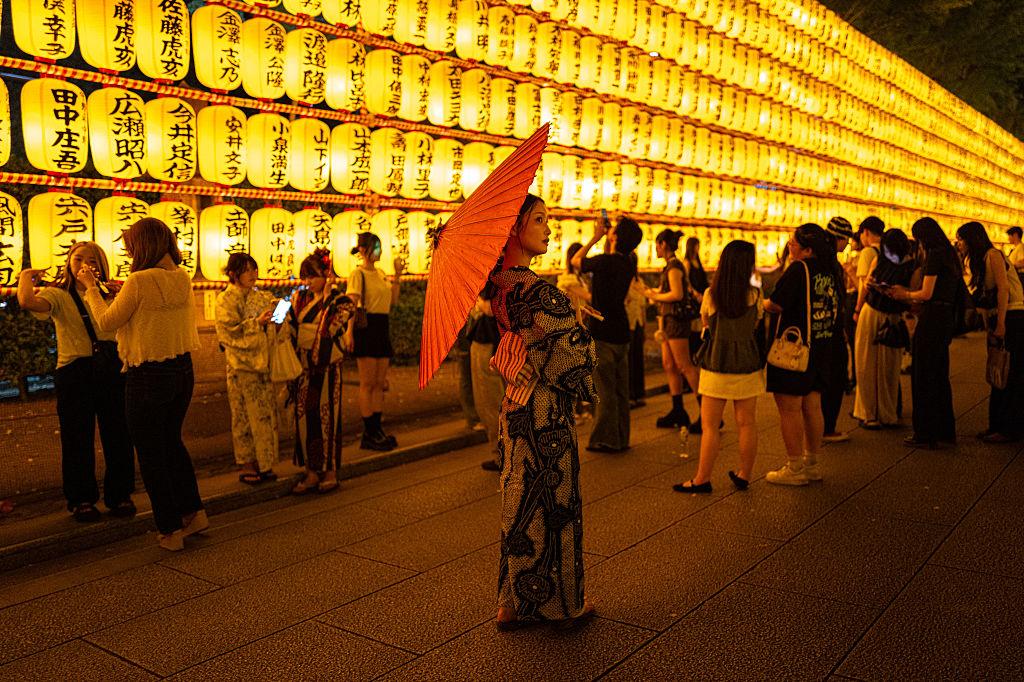 People gather in front of thousands of lanterns on display during the Mitama Matsuri, one of the capital's largest summer "obon" festivals, at Yasukuni Shrine in Tokyo on July 15, 2026. (Philip Fong/AFP via Getty Images)