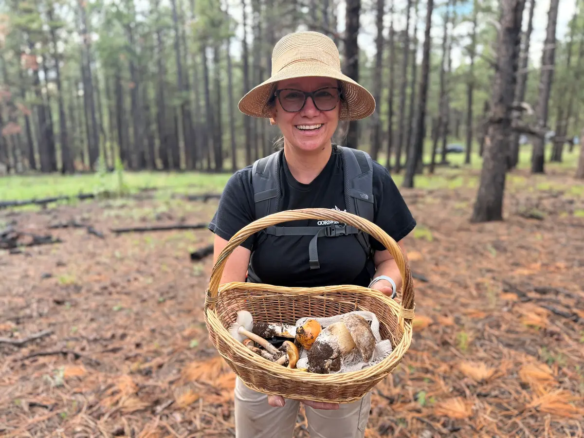 Amateur mushroom hunter Crystal Randall holds a basket filled with edible wild mushrooms on Aug. 14, 2026. (Allan Stein/The Epoch Times)