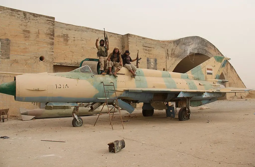 Members of Al-Qaeda's Syrian affiliate, Al-Nusra Front, and its allies sit on top of a former Syrian army MiG-21 fighter jet after seizing the Abu al-Duhur Airbase in northwestern Idlib province on Sept. 9, 2015. (Omar Haj Kadour/AFP Photo)