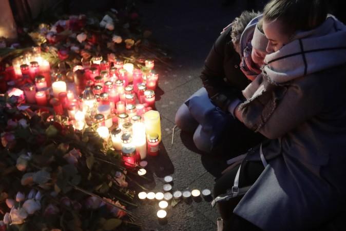 Two women mourn beside candles in Berlin, Germany on Dec. 20, 2016. (AP Photo/Markus Schreiber)