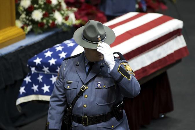 A Georgia State Trooper pay his respects to Americus Police Officer Nicholas Smarr on Dec. 11, who was killed after responding to a domestic disturbance call in Americus, Ga. (AP Photo/Branden Camp)