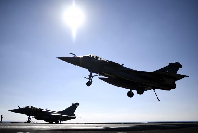 A French Rafale fighter jet lands on the deck of France's aircraft carrier Charles-de-Gaulle operating in the eastern Mediterranean Sea on Dec. 9, as part of an international coalition against the ISIS. (STEPHANE DE SAKUTIN/AFP/Getty Images)
