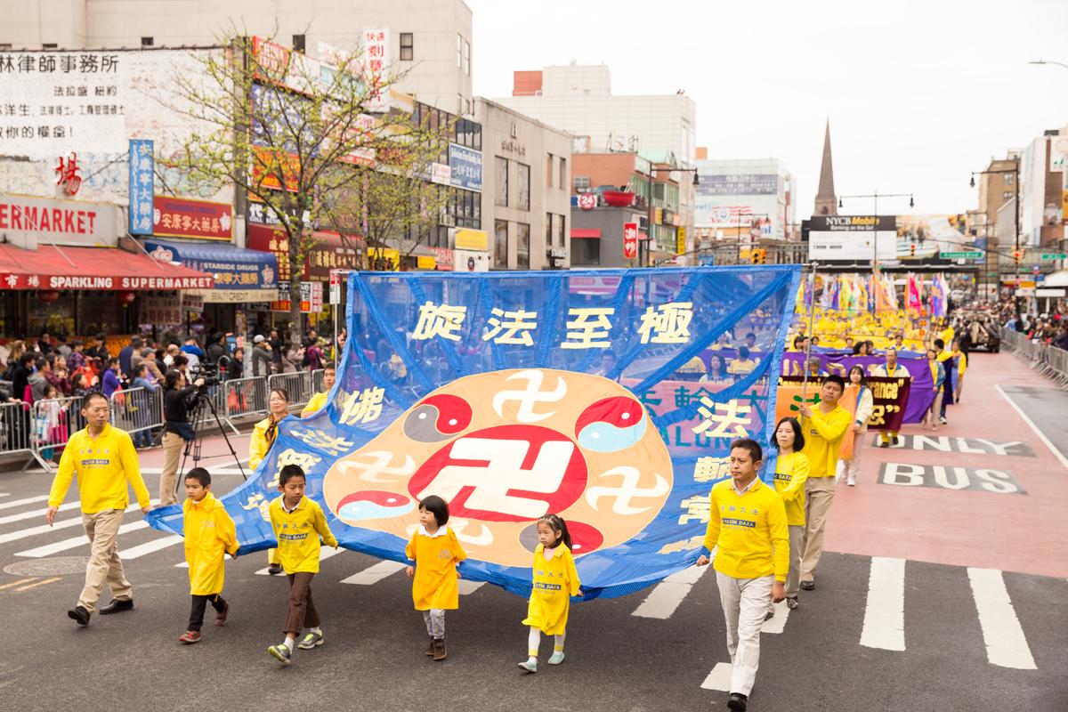 Falun Gong practitioners participating in the Flushing parade hold a large banner showing the Law Wheel symbol of Falun Gong. (Larry Dye/Epoch Times)