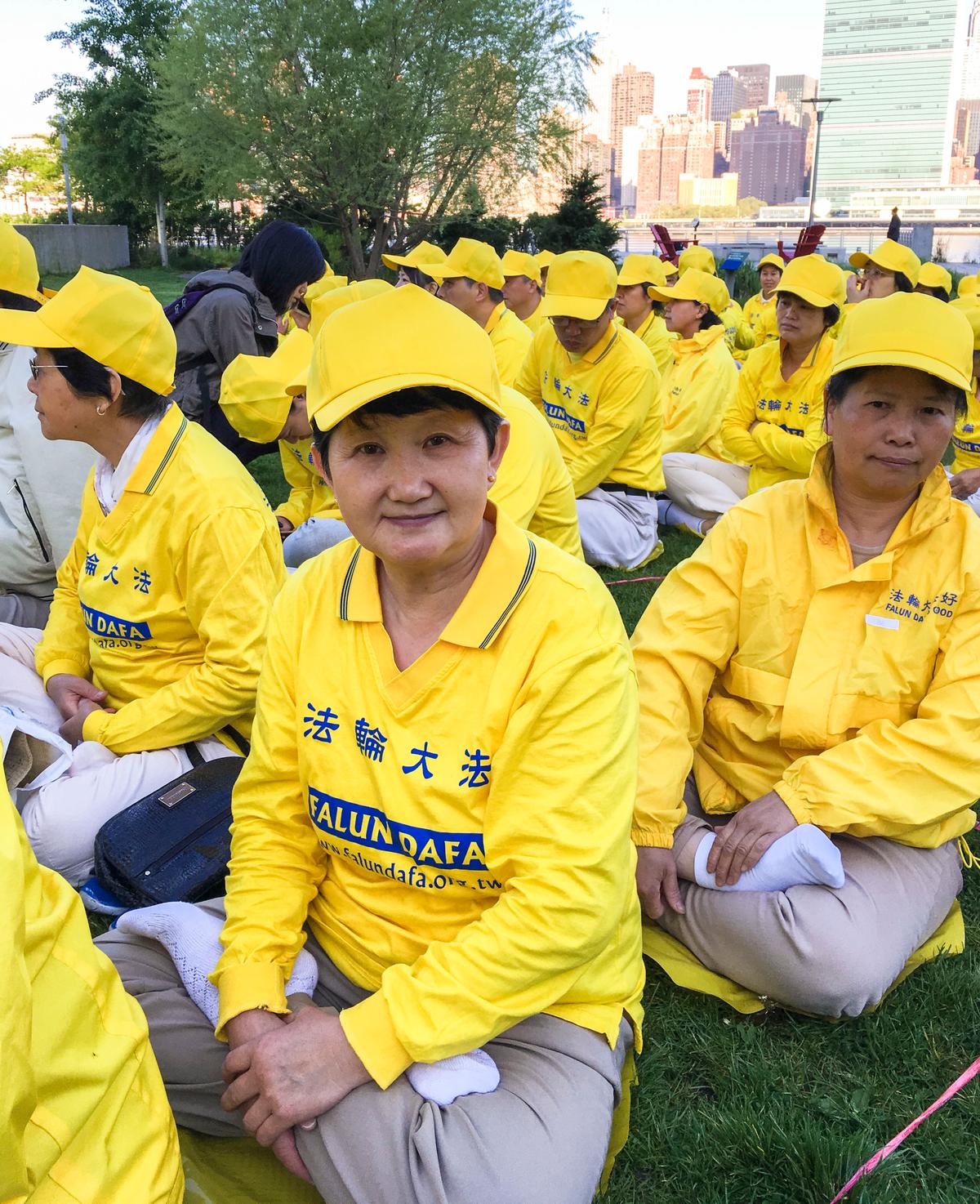 Zhang Guanghua (C), a Falun Gong practitioner from Beijing, joins a character formation event at Gantry Plaza State Park on May 12, 2016. (Larry Ong/Epoch Times)