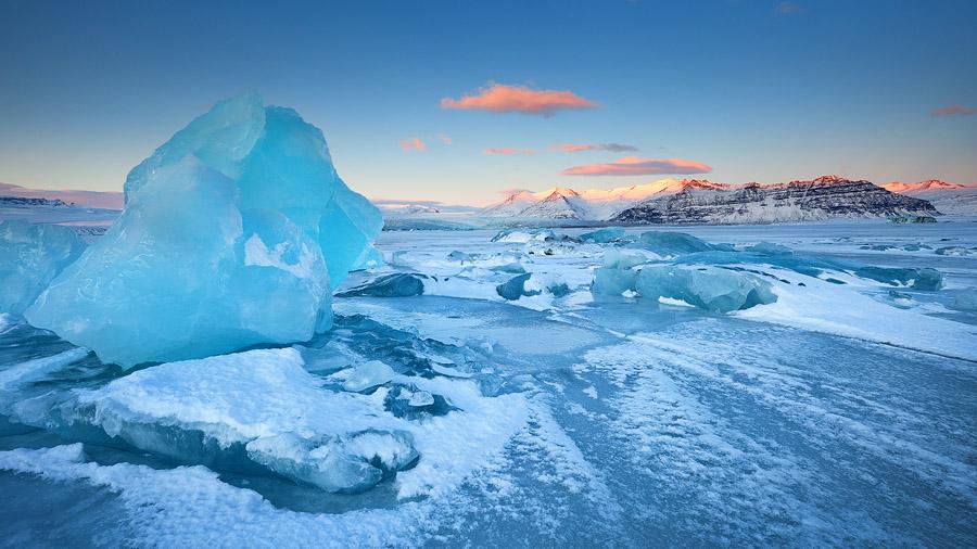 <br/>"Fields of Ice." Photographer Erez Marom describes: "The frozen lagoon in front of Breiðamerkurjökull glacier was an amazing place to visit. Endless fields of blue icebergs, some as big as a house, assumed countless forms and triggered everyone's imagination. The soft morning sun colored the mountaintops red, to complement the scene." (Erez Marom)