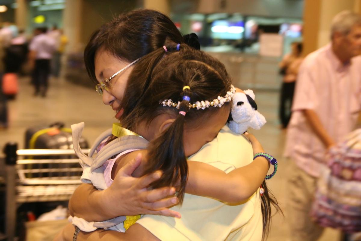 TOGETHER AT LAST: Miao Miao and her 6-year-old daughter Hua Yuchen share a touching moment at Don Muang International Airport in Bangkok on January 23, 2006. They were separated after Miao was imprisoned at the Bangkok Immigration Detension Center following an arrest that many believe was illegal. They flew to asylum in Norway early morning on the 24th. (The Epoch Times)