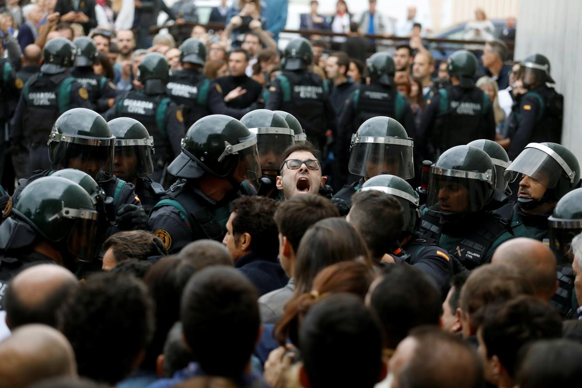 Scuffles break out as Spanish Civil Guard officers force their way through a crowd and into a polling station for the banned independence referendum where Catalan President Carles Puigdemont was supposed to vote in Sant Julia de Ramis, Spain on Oct. 1, 2017. (REUTERS/Juan Medina)