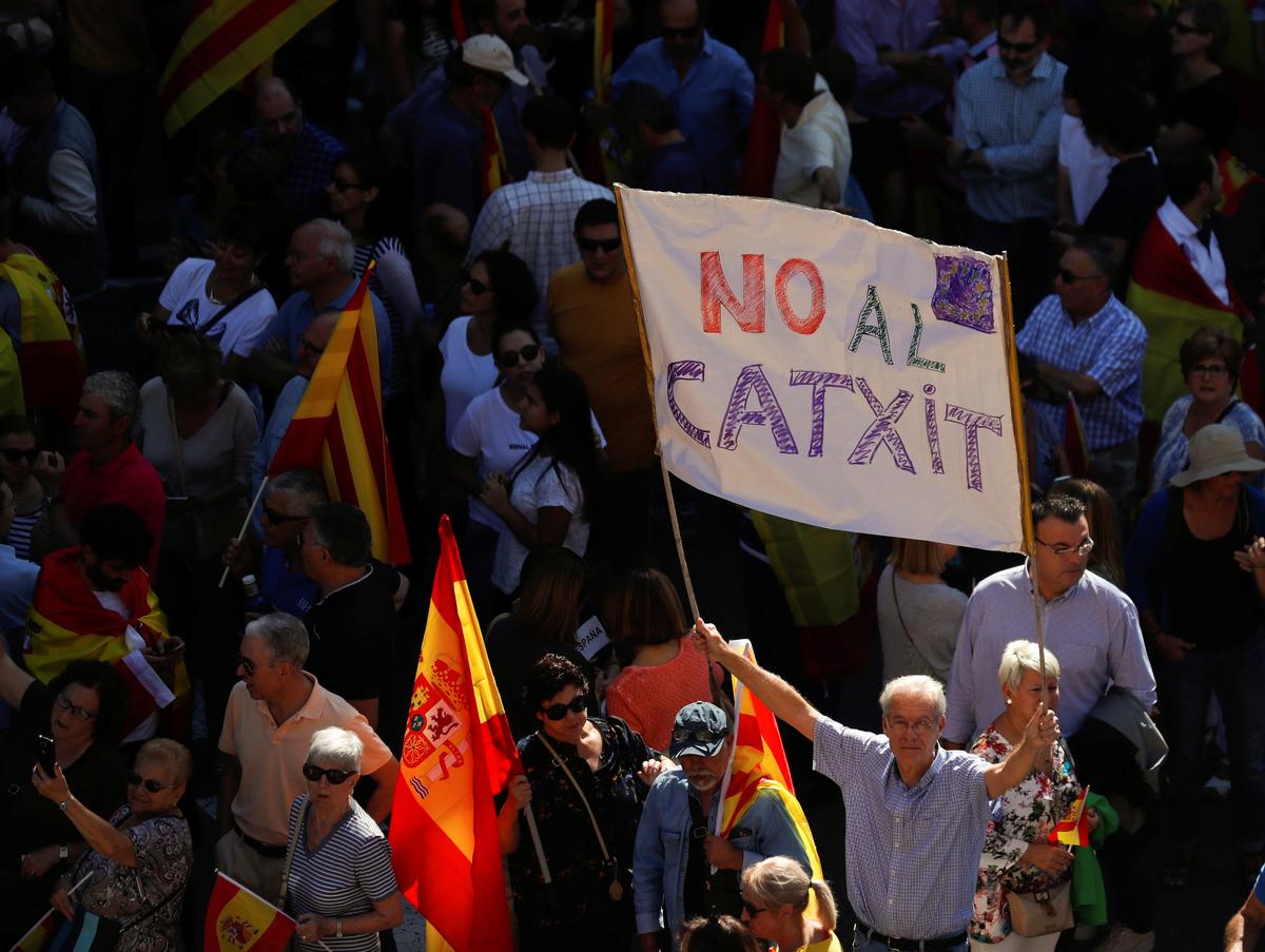 A man holds up a banner reading "No Catxit" in reference to a Catalan Brexit, during a pro-union demonstration organised by the Catalan Civil Society organisation in Barcelona, Spain on Oct. 8, 2017. (REUTERS/Rafael Marchante)