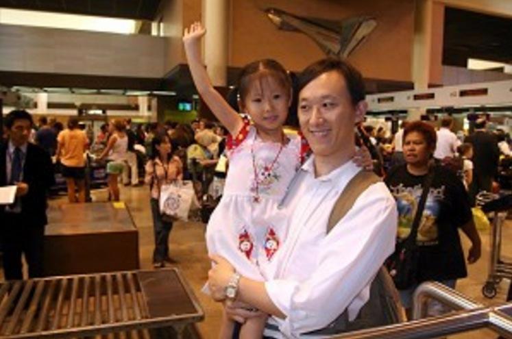 DON MUANG AIRPORT, BANGKOK: Huang Guohua and his 4-year-old daughter Huang Ying enjoy a happy moment while preparing to board a flight to New Zealand where they are being resettled, on Jan. 15, 2006. (The Epoch Times)