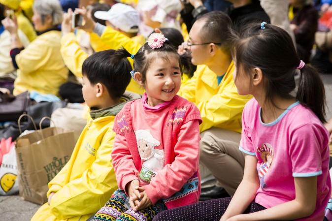 Little girls react after watching the Falun Dafa dragon dance team perform. (Samira Bouaou/The Epoch Times)