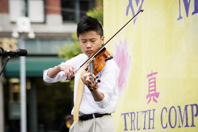 Yuan Yuan, a young violin soloist performs during the World Falun Dafa Day event at Union Square, New York City, on May 11, 2017. (Samira Bouaou/The Epoch Times)