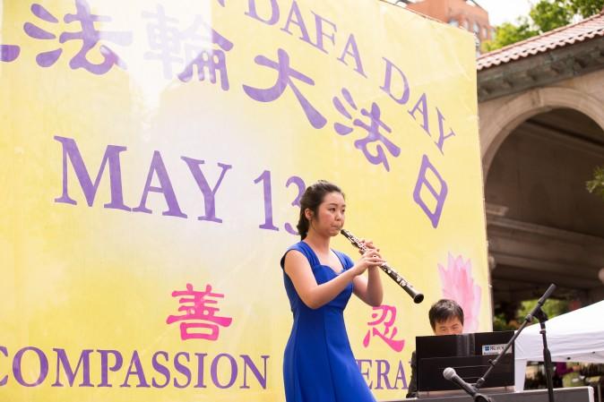 Lleana Feng plays the Oboe during the World Falun Dafa Day event at Union Square, New York City, on May 11, 2017. (Larry Dye/The Epoch Times)