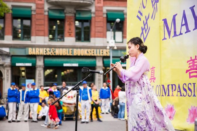 Yue Dai plays the hulusi, an ethnic instrument made of gourd and bamboo, during the World Falun Dafa Day event at Union Square, New York City, on May 11, 2017. (Benjamin Chasteen/The Epoch Times)