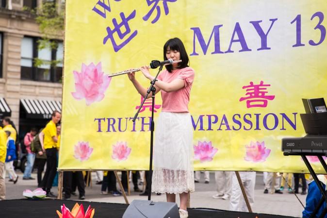 A woman plays the flute during the World Falun Dafa Day event at Union Square, New York City, on May 11, 2017. (Benjamin Chasteen/The Epoch Times)