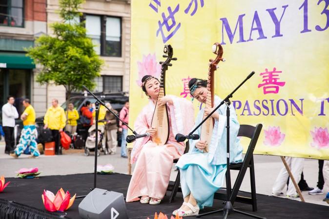 Jia Ge and Le Le play the Chinese traditional pipa instrument during the World Falun Dafa Day event at Union Square, New York City, on May 11, 2017. (Benjamin Chasteen/The Epoch Times)