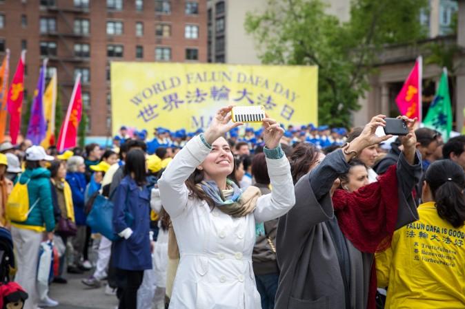 Two woman take selfies during the World Falun Dafa Day event at Union Square, New York City, on May 11, 2017. (Benjamin Chasteen/The Epoch Times)
