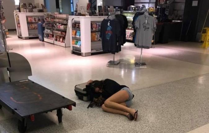 A newly-wed Rachel Brumfield sleeps on the floor at baggage claim. (Facebook)