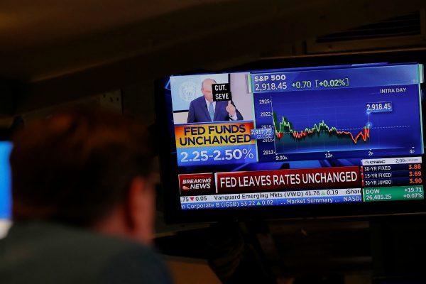 A trader looks at a screen as a television announces that the Fed rate will remain unchanged on the floor of the New York Stock Exchange in New York, on June 19, 2019. (Lucas Jackson/Reuters)