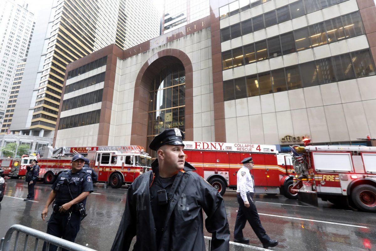 New York City Police and Fire Department personnel secure the scene in front of a building in midtown Manhattan where a helicopter crash landed on June 10, 2019. (AP Photo/Richard Drew)