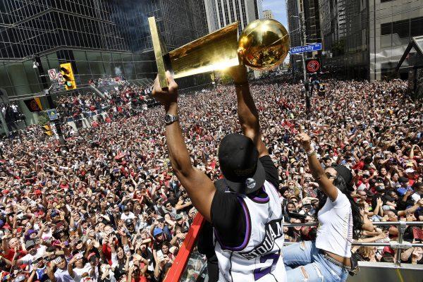 Toronto Raptors guard Kyle Lowry holds the Larry O'Brien Championship Trophy up for the fans during the NBA basketball championship team's victory parade in Toronto, on June 17, 2019. (Frank Gunn/The Canadian Press via AP)