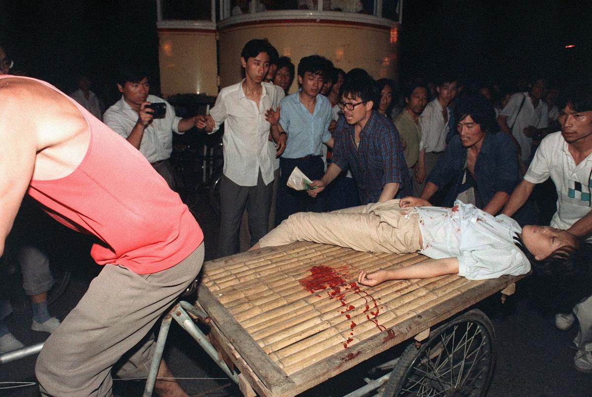 A girl wounded during the clash between the army and students 04 June 1989 near Tiananmen Square is carried out by a cart (MANUEL CENETA/AFP/Getty Images)