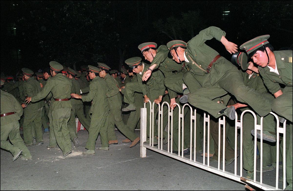 People Liberation Army (PLA) soldiers leap over a barrier on Tiananmen Square in central Beijing 04 June 1989. (CATHERINE HENRIETTE/AFP/Getty Images)