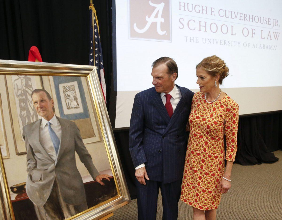 Hugh F. Culverhouse Jr. and his wife, Eliza, look at a portrait of him that will hang in the University of Alabama law school in Tuscaloosa, Ala., on Sept. 20, 2018. (Gary Cosby Jr./The Tuscaloosa News via AP)