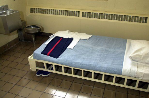 Prison inmate clothes lie on a bed in a holding cell in a file photo. (Photo by Mike Simons/Getty Images)