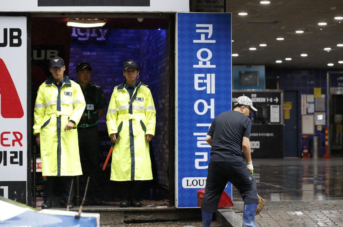 Police stand at the doorway to a nightclub in Gwangju, South Korea, July 27, 2019. (AP Photo/Lee Jin-man)