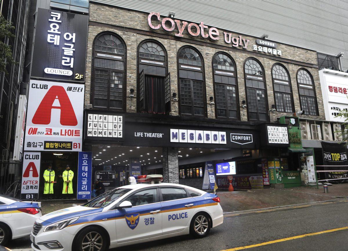 Police stand at the door to a nightclub in Gwangju, South Korea, July 27, 2019. Members of the U.S. national water polo team were in a South Korean nightclub when an internal balcony collapsed, killing at least one person. A local news agency has reported that one person has died, with 13 injured. No U.S. swimmers were at the club at the time. (AP Photo/Lee Jin-man)