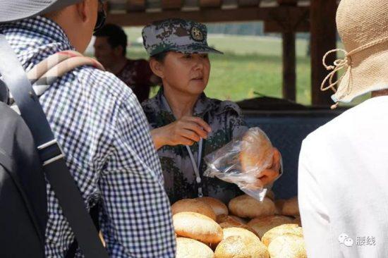 A woman in camouflage uniform is selling bread in Xinjiang, China on June 2019. (WeChat user "Sang Sang")