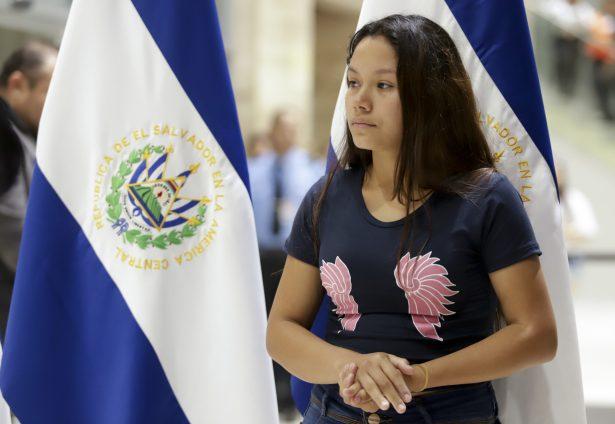 Tania Vanessa Avalos stands nearby as a government official speaks at a press conference at the airport, after her arrival in San Salvador, El Salvador on June 28, 2019. (AP Photo/Salvador Melendez)