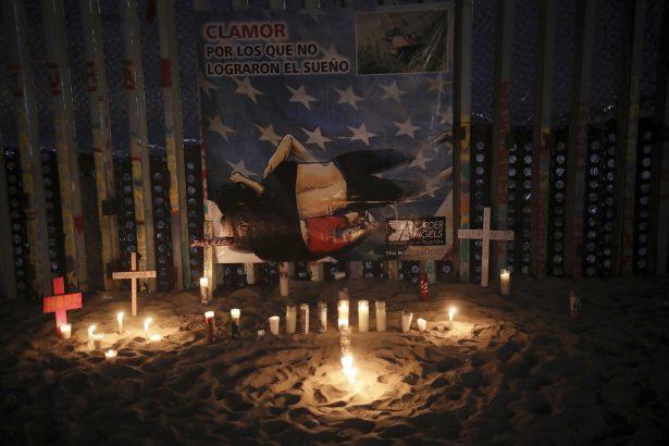 Candles are placed next to the border fence that separates Mexico from the United States, in memory of migrants who have died during their journey toward the U.S., in Tijuana, Mexico, on June 29, 2019. (AP Photo/Emilio Espejel)