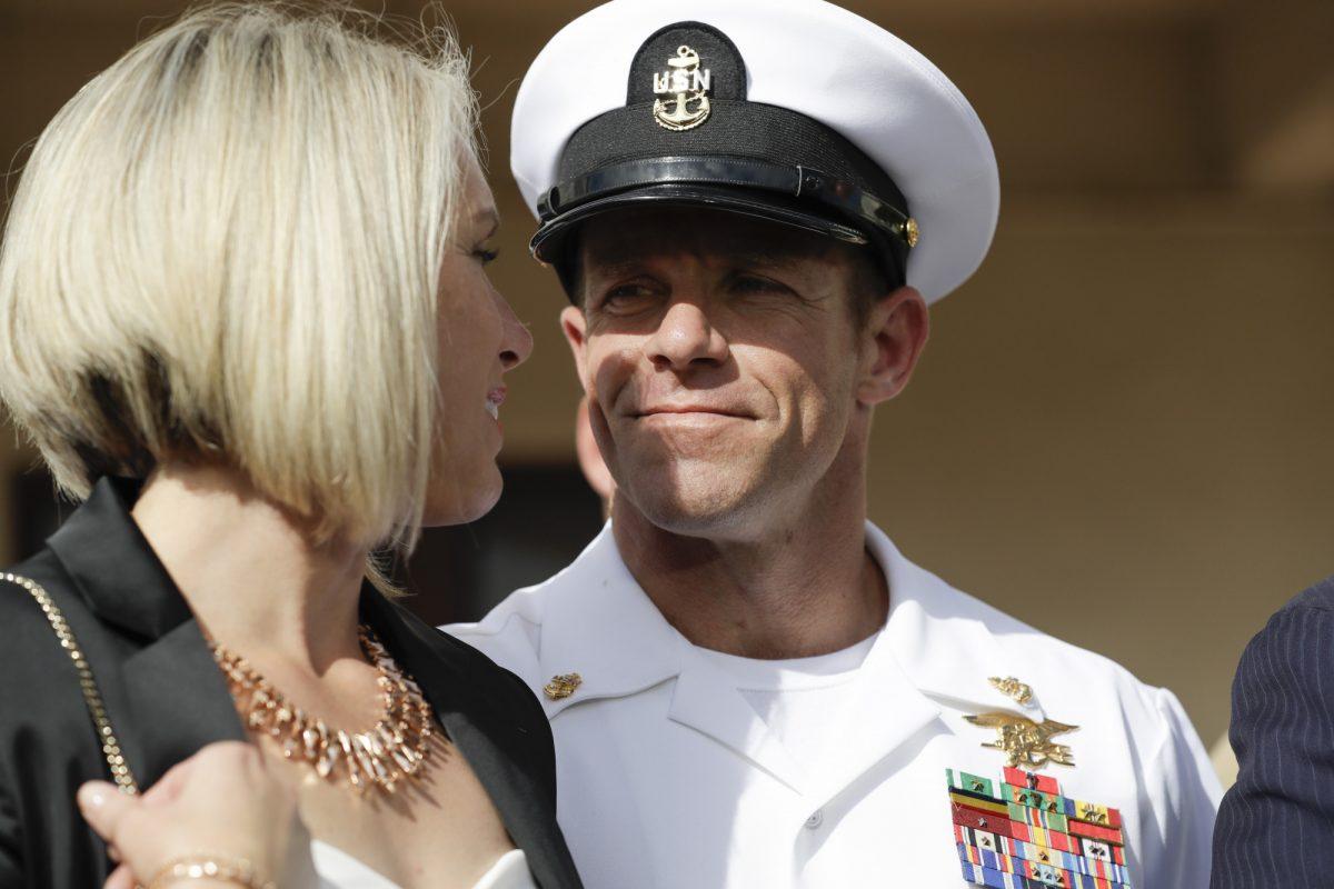 Navy Special Operations Chief Edward Gallagher, right, walks with his wife, Andrea Gallagher as they leave a military court on Naval Base San Diego, July 2, 2019, in San Diego. A military jury acquitted the decorated Navy SEAL Tuesday of murder in the killing of a wounded Islamic State captive under his care in Iraq in 2017. (AP Photo/Gregory Bull)