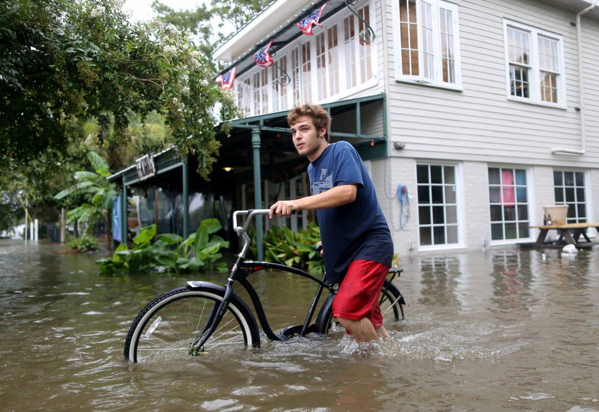 Logan Courvlle pushes his bike through a flooded street after Hurricane Barry in Mandeville, , U.S., on July 13, 2019. (Jonathan Bachman/Reuters)