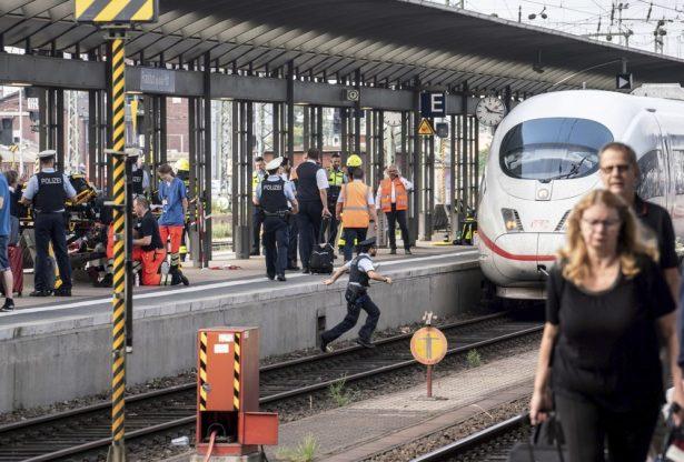 Firefighters and Police officers stay next to an ICE highspeed train at the main station in Frankfurt, Germany on July 29, 2019. (Frank Rumpenhorst/dpa via AP)