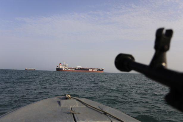 a speedboat of Iran's Revolutionary Guard trains a weapon toward the British-flagged oil tanker Stena Impero, which was seized in the Strait of Hormuz by the Guard, in the Iranian port of Bandar Abbas, on July 19, 2019.(Morteza Akhoondi/Tasnim News Agency via AP)