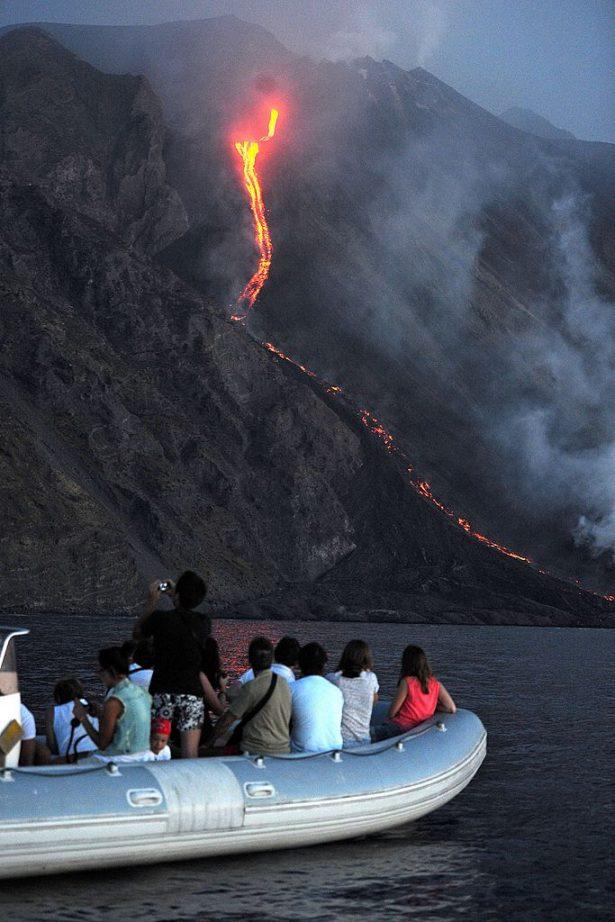 A boat of tourists watches as lava from the Stromboli volcano flows into the sea, on Aug 9, 2014. (Giovanni Isolino/AFP/Getty Images)