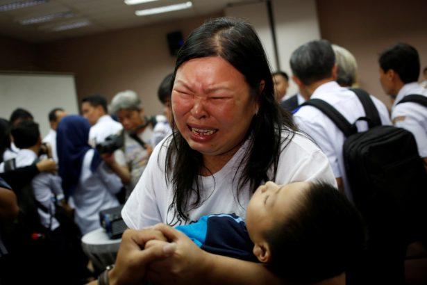 A woman, whose husband was on Lion Air flight JT610, cries as she holds their son after a news conference about the recovery process at a hotel in Jakarta, Indonesia, on Nov. 5, 2018. (Willy Kurniawan/Reuters)