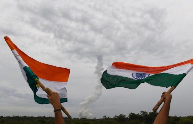 Indian residents wave Indian national flags as The Indian Space Research Organisation's (ISRO) Chandrayaan-2 (Moon Chariot 2), on board the Geosynchronous Satellite Launch Vehicle (GSLV-mark III-M1), launches in Sriharikota in the state of Andhra Pradesh on July 22, 2019. (Arun Sankar/AFP/Getty Images)