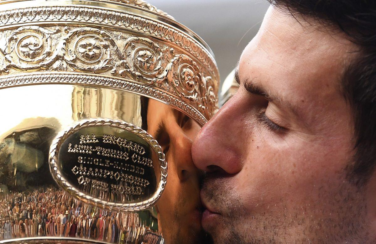 Novak Djokovic kisses the trophy during the presentation after he defeated Switzerland's Roger Federer during the men's singles final match of the Wimbledon Tennis Championships in London, on July 14, 2019. (Laurence Griffiths/Pool Photo via AP)
