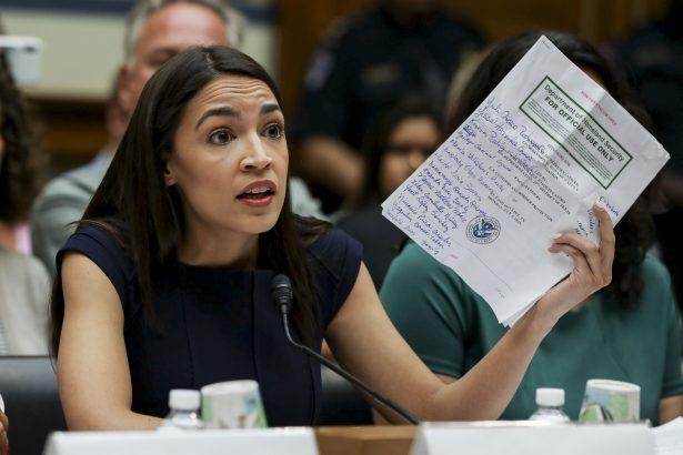 Rep. Alexandria Ocasio-Cortez (D-NY) holds up a paper with names of asylum-seekers written on it in Washington on July 12, 2019. (Charlotte Cuthbertson/The Epoch Times)