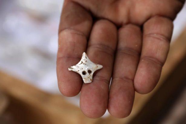 A mother of pearl pendant discovered on a skeleton at the site. (Gali Tibbon/AFP/Getty Images)