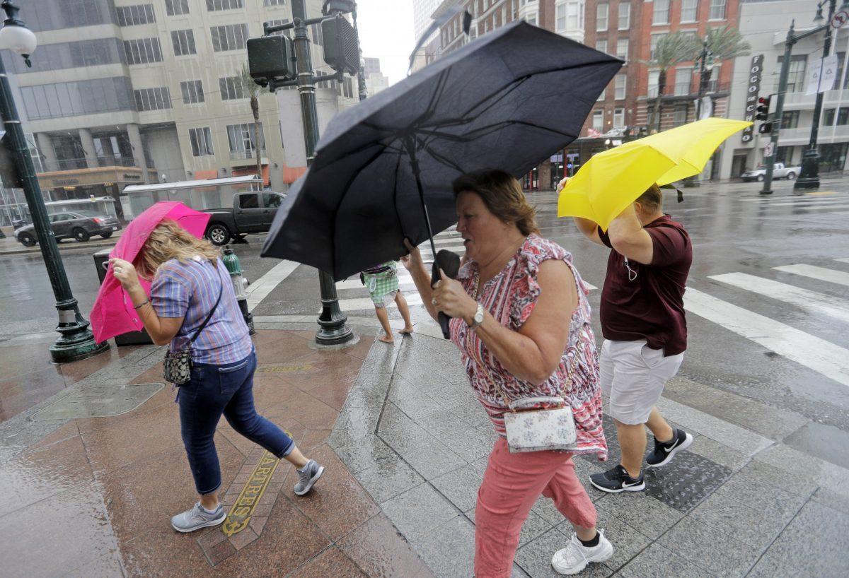 People walking on the street while battling the wind and rain from Hurricane Barry as it nears landfall in New Orleans, La., on July 13, 2019. (David J. Phillip/AP Photo)