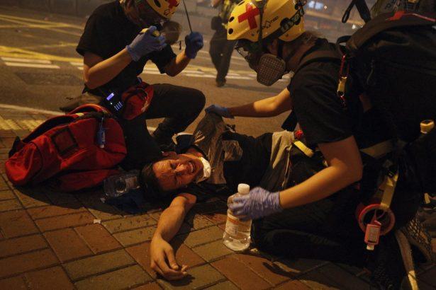 Medical workers help a protester in pain from tear gas fired by policemen on a street in Hong Kong, on July 21, 2019. (Bobby Yip/AP Photo)