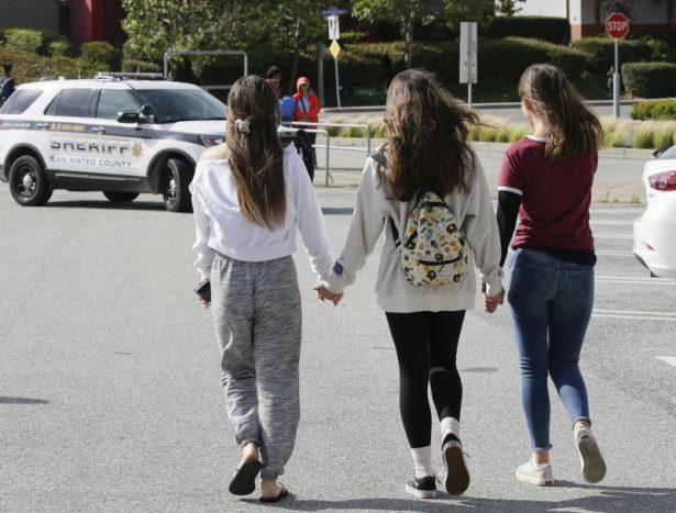 Three teens hold hands after being escorted from the Tanforan Mall in San Bruno, Calif., on July 2, 2019. (Stephanie Mullen/AP Photo)