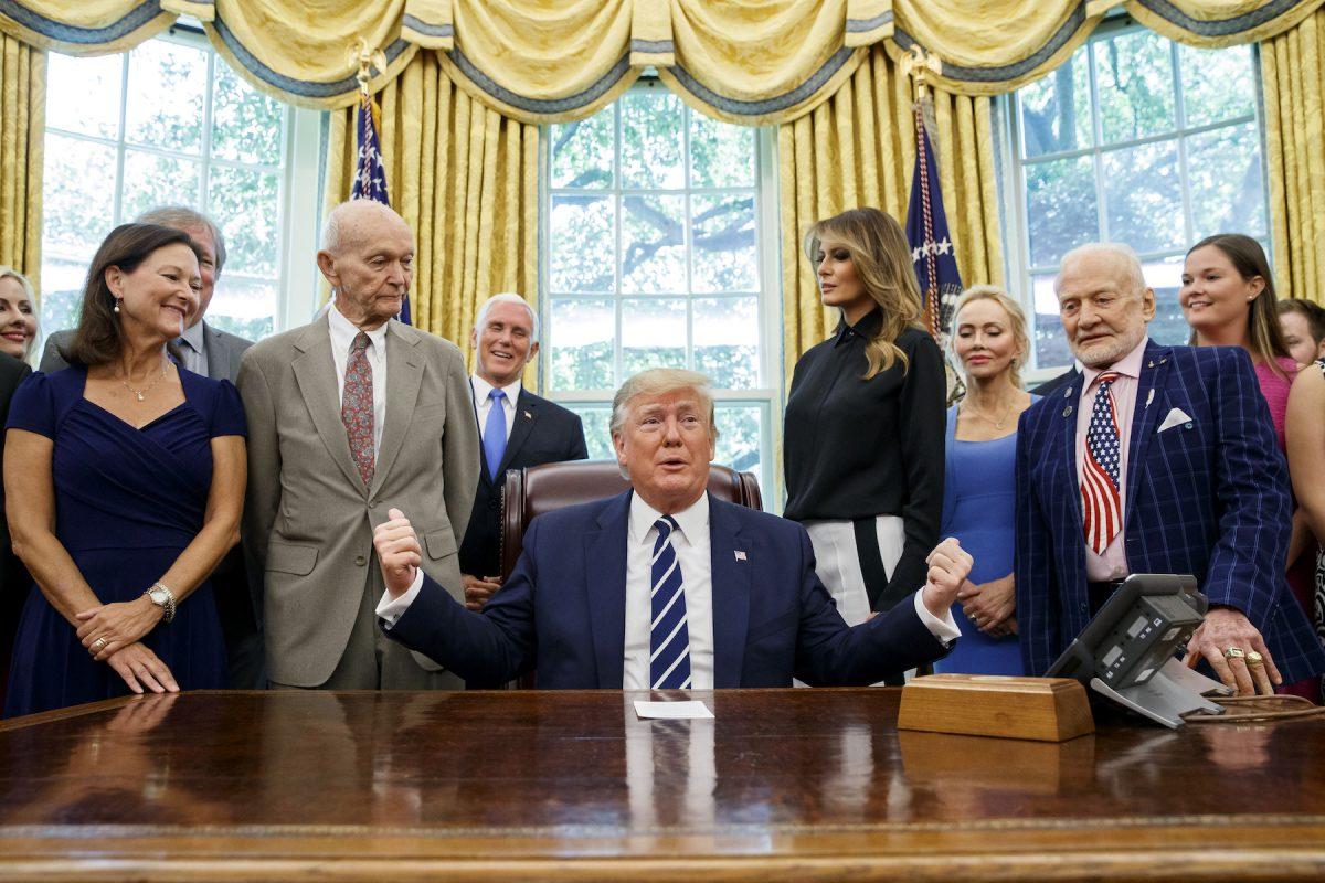 President Donald Trump, accompanied by Apollo 11 astronauts Micheal Collins, second from left, and Buzz Aldrin, second from right, with Vice President Mike Pence and first lady Melania Trump, speaks during a photo opportunity commemorating the 50th anniversary of the Apollo 11 moon landing, in the Oval Office of the White House in Washington, on July 19, 2019. (AP Photo/Alex Brandon)