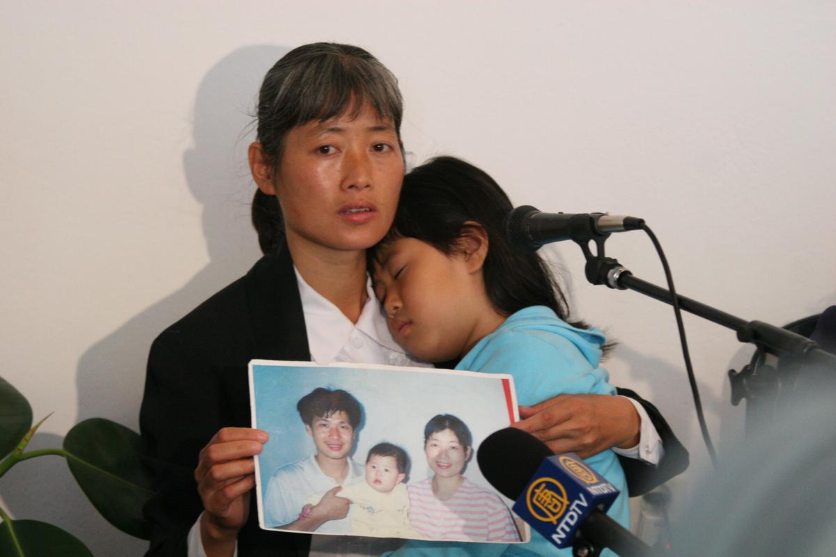 PAIN LINGERS: Ms. Zhizhen Dai, panelist at the "Never Again: Appeal to the World" forum discussing illegal organ harvesting in death camps in China, speaks of the 2001 torture and murder of her husband at the hands of Chinese authorities. Her daughter Fadu naps in her arms. The forum was held in Auschwitz, Poland on May 9, 2006. (Jan Jekielek/The Epoch Times)