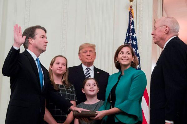 Brett Kavanaugh (L) is sworn in as Associate Justice of the Supreme Court by retired Associate Justice Anthony Kennedy (R) before wife Ashley Estes Kavanaugh (2nd-R), daughters Margaret (2nd-L) and Elizabeth (C), and President Donald Trump at the White House on Oct. 8, 2018. (Jim Watson/AFP/Getty Images)