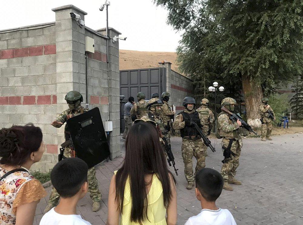 Kyrgyz special forces stand in guard at former president of Kyrgyzstan Almazbek Atambayev's residence in the village of Koi-Tash, about 20 kilometers (12 miles) south of the capital, Bishkek, Kyrgyzstan, on Aug. 7, 2019. (AKIpress via AP)